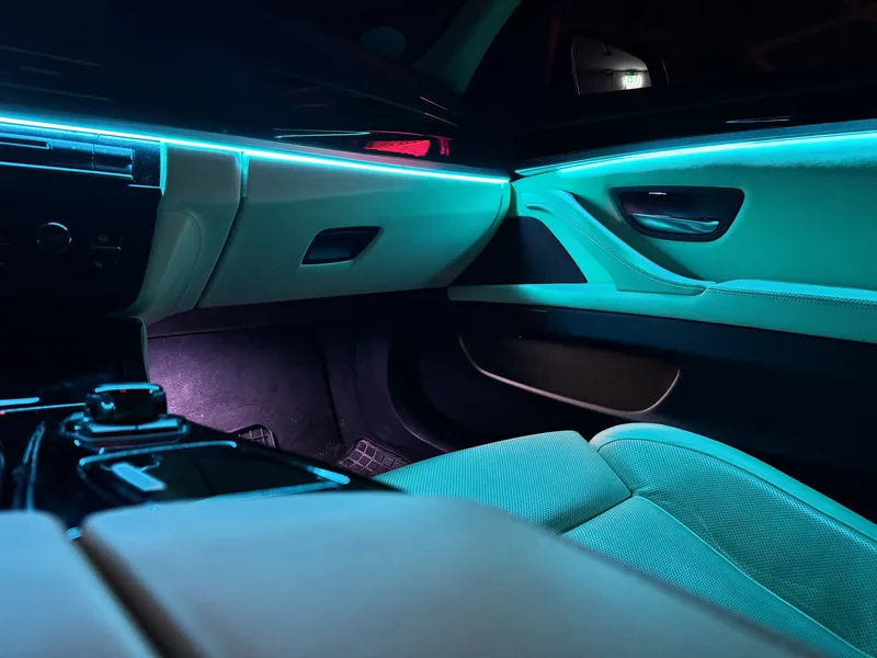 Türkise Lichtlinie am Armaturenbrett und an der Beifahrertür des BMW 3er