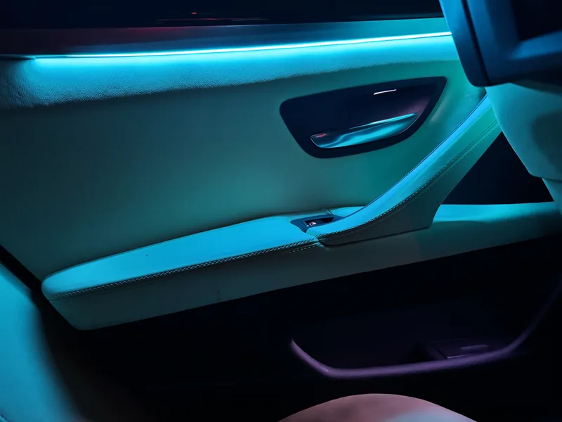 Detail der türkisen Lichtlinie in einer Türverkleidung des BMW 3er