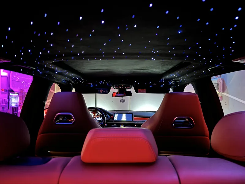 Blick aus dem Fond des BMW X5 auf Sternenhimmel und Cockpit