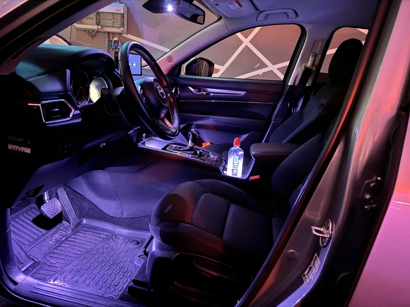 Blick durch die Fahrertür auf die violette Ambientebeleuchtung im Mazda CX-5