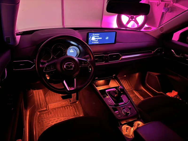 Cockpit des Mazda CX-5 mit orange beleuchtetem Fußraum